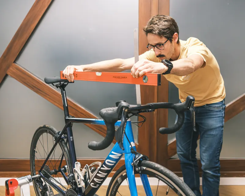 Florent Lemaire, kinésithérapeute et bikefitter, vérifie le niveau d'un cintre de vélo de route