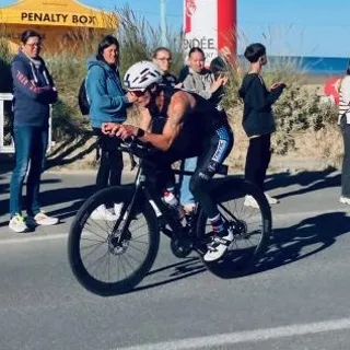 Triathlète en position aérodynamique sur vélo de contre-la-montre après son étude posturale